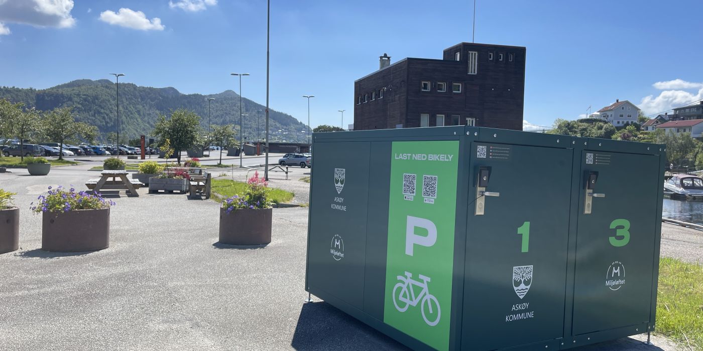 En grønn boks på en parkeringsplass, boksen er stor nok til å inneholde fire sykler
