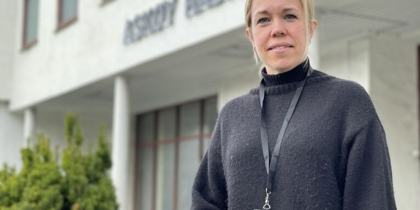 En dame utenfor et stort hus